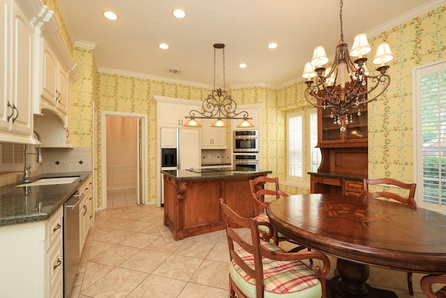 kitchen featuring wallpapered walls, appliances with stainless steel finishes, a sink, a kitchen island, and ornamental molding