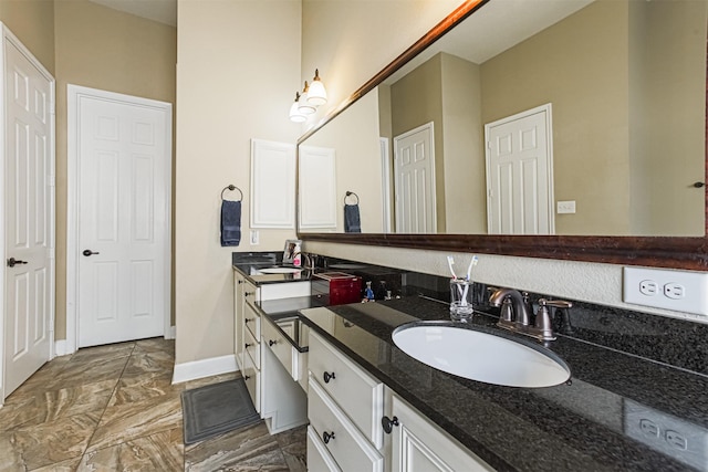 bathroom featuring baseboards, marble finish floor, and vanity