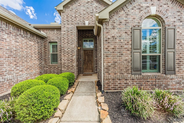 doorway to property featuring brick siding