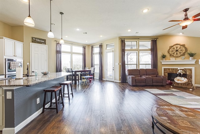 living room featuring a ceiling fan, dark wood finished floors, baseboards, a high end fireplace, and recessed lighting
