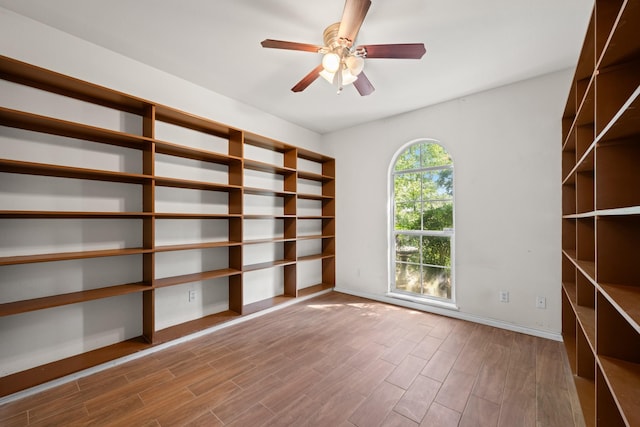 spare room featuring baseboards, ceiling fan, and wood finished floors