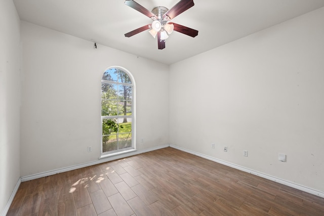 unfurnished room with baseboards, wood finished floors, and a ceiling fan