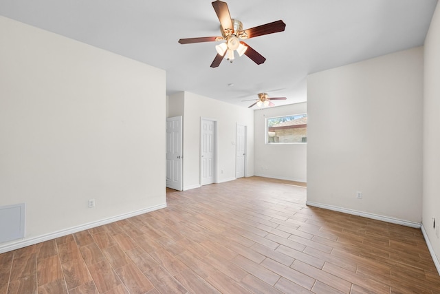empty room featuring light wood-type flooring, baseboards, and ceiling fan