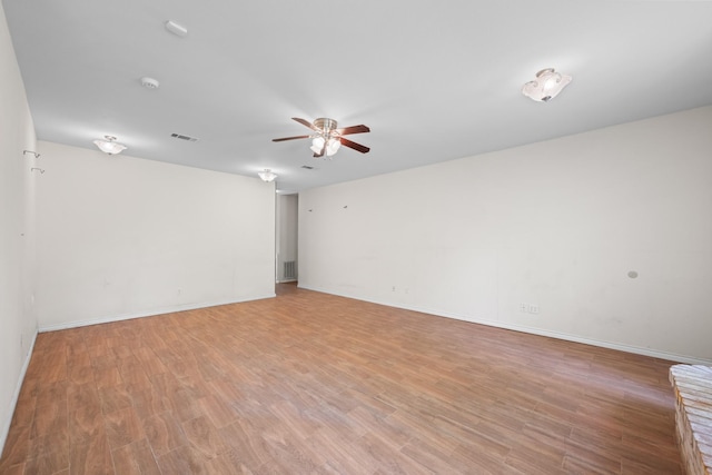 unfurnished room with light wood finished floors, visible vents, baseboards, and ceiling fan