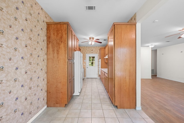 kitchen with freestanding refrigerator, ceiling fan, visible vents, and wallpapered walls