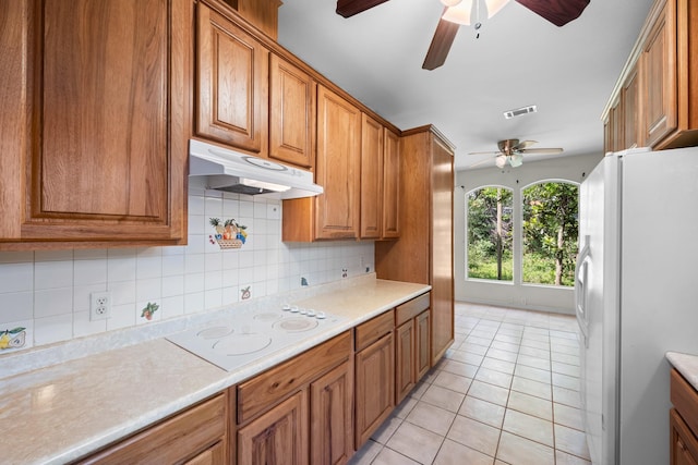 kitchen with under cabinet range hood, white appliances, a ceiling fan, and brown cabinets