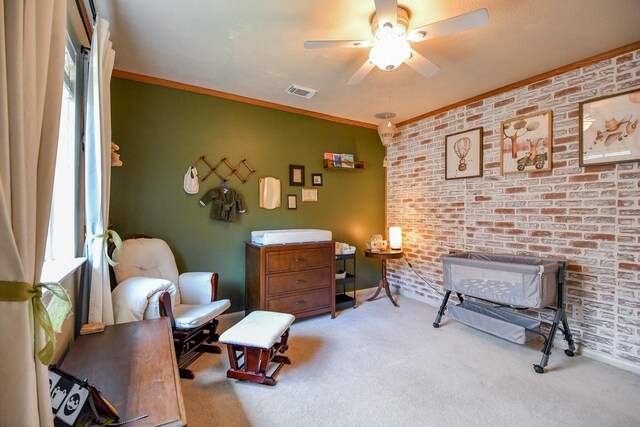 sitting room with carpet, ceiling fan, brick wall, crown molding, and baseboards
