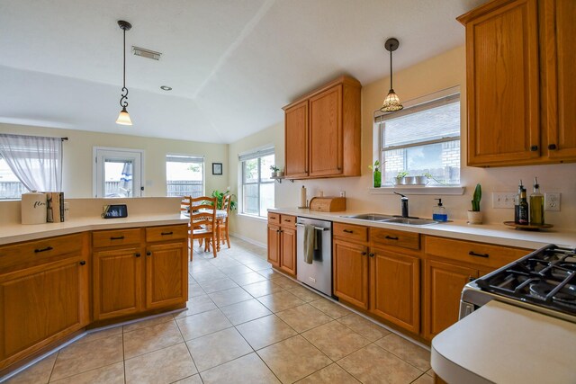 kitchen with stainless steel appliances, a sink, brown cabinetry, light countertops, and pendant lighting