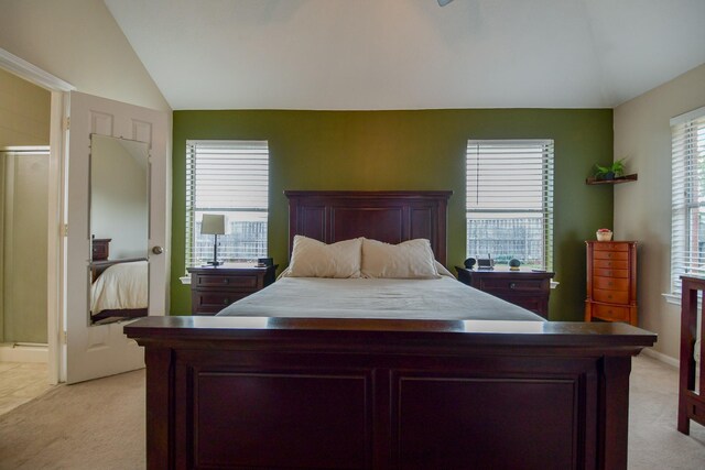 bedroom featuring lofted ceiling, light colored carpet, and baseboards