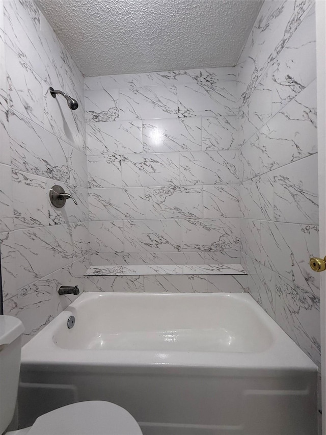 full bath featuring toilet, bathtub / shower combination, and a textured ceiling