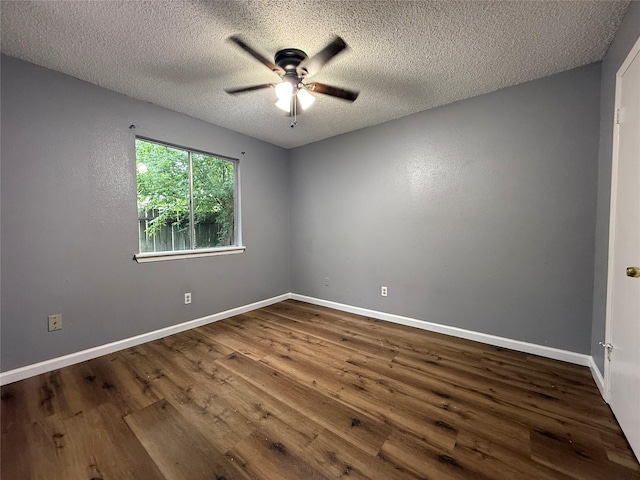 unfurnished room with ceiling fan, a textured ceiling, baseboards, and dark wood-type flooring