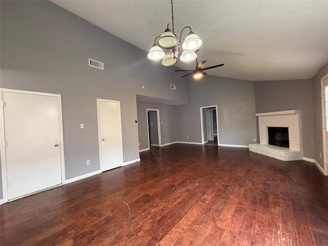unfurnished living room featuring a textured ceiling, visible vents, ceiling fan with notable chandelier, a brick fireplace, and high vaulted ceiling