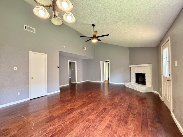 8715 Belle Glen Dr, Houston, TX 77099 - unfurnished living room featuring a textured ceiling, a ceiling fan, a brick fireplace, wood finished floors, and high vaulted ceiling