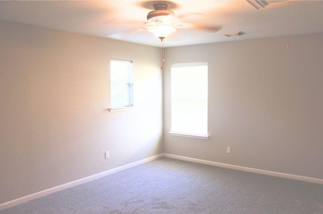 carpeted empty room featuring a ceiling fan and baseboards