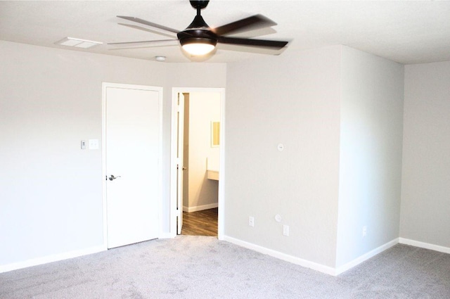 unfurnished bedroom with carpet floors, baseboards, ensuite bathroom, and ceiling fan