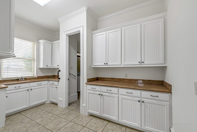 1006 Cross Hollow Ln, Katy, TX 77494 - kitchen featuring white cabinetry, light tile patterned floors, and crown molding