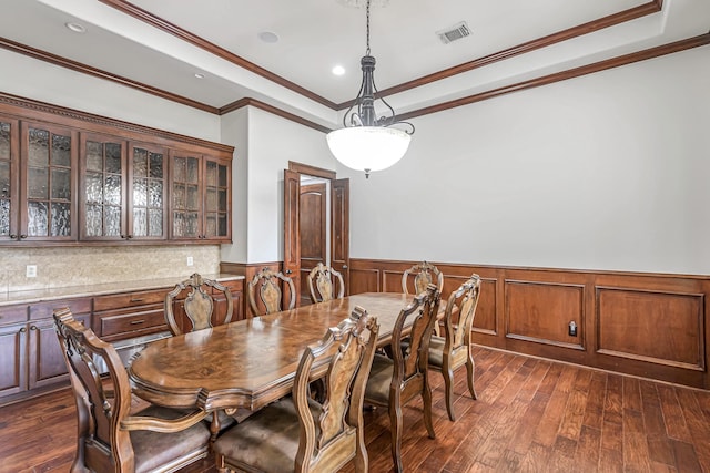1006 Cross Hollow Ln, Katy, TX 77494 - dining room featuring dark wood-style flooring, a raised ceiling, a wainscoted wall, and visible vents