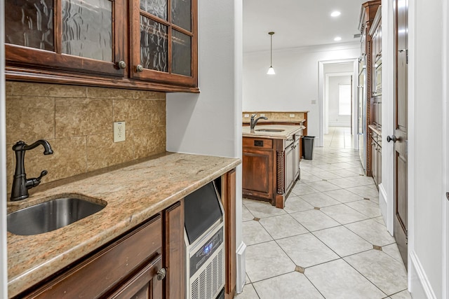 1006 Cross Hollow Ln, Katy, TX 77494 - kitchen with backsplash, crown molding, light stone counters, and a sink
