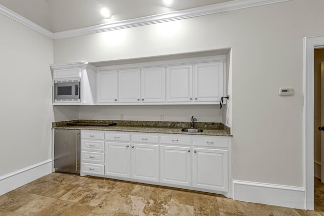 1006 Cross Hollow Ln, Katy, TX 77494 - kitchen with crown molding, a sink, appliances with stainless steel finishes, white cabinetry, and dark stone countertops