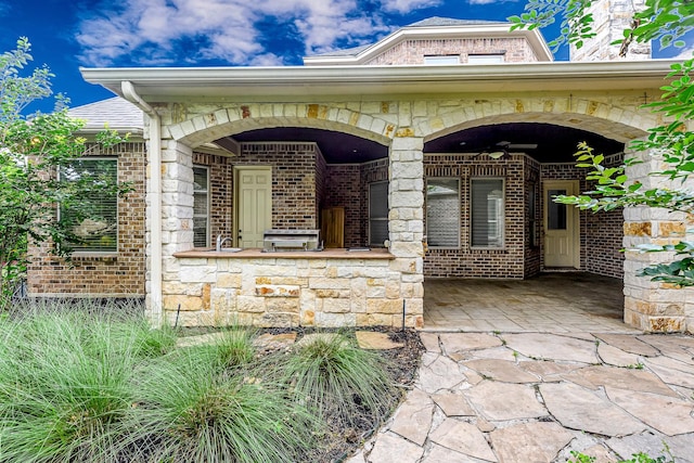 1006 Cross Hollow Ln, Katy, TX 77494 - view of exterior entry with ceiling fan, brick siding, and stone siding