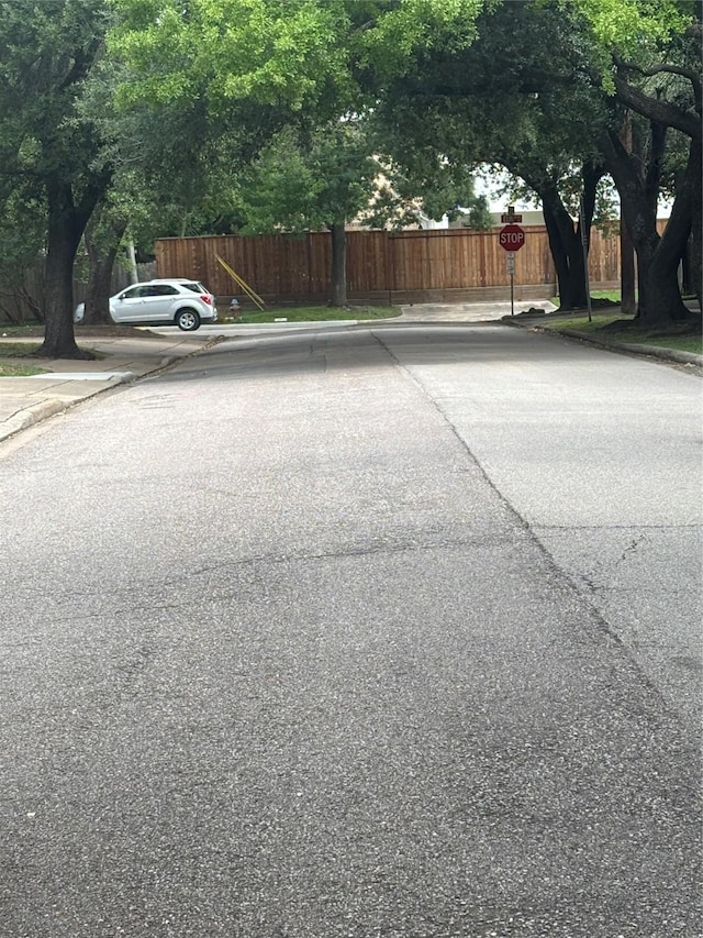 6314 1st St, Bellaire, TX 77401 - view of asphalt road with curbs and traffic signs