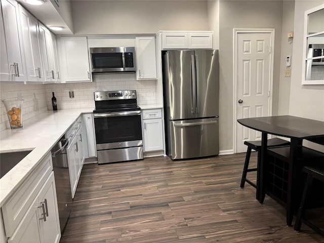 6314 1st St, Bellaire, TX 77401 - kitchen with appliances with stainless steel finishes, tasteful backsplash, dark wood-type flooring, and white cabinets