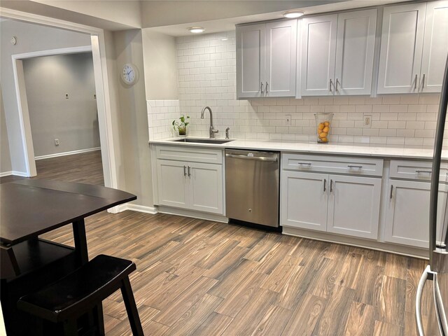 6314 1st St, Bellaire, TX 77401 - kitchen featuring dishwasher, a sink, decorative backsplash, dark wood-style floors, and baseboards