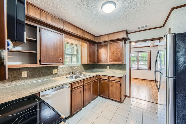 kitchen with visible vents, a sink, crown molding, stainless steel appliances, and tasteful backsplash