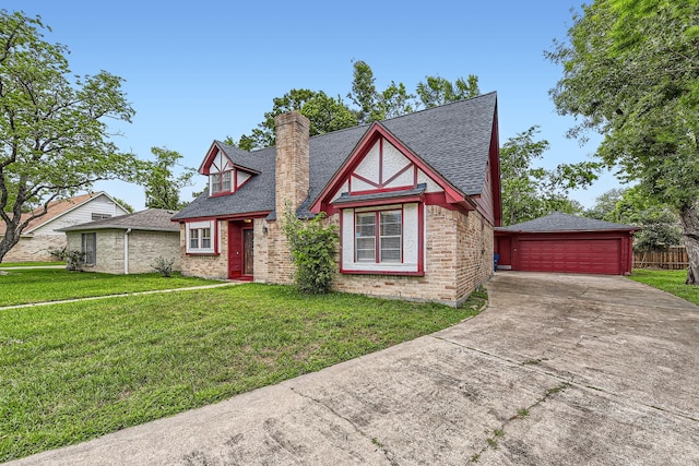 tudor home with a shingled roof, brick siding, a chimney, and a front lawn