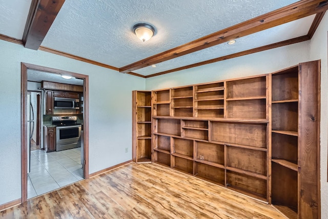 empty room featuring light wood finished floors, crown molding, a textured ceiling, baseboards, and beamed ceiling