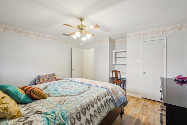 bedroom featuring light wood-type flooring, visible vents, and a ceiling fan