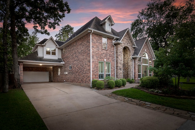 traditional-style house featuring concrete driveway, stone siding, a shingled roof, and a garage