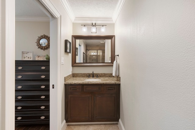 bathroom featuring crown molding, a textured ceiling, baseboards, and vanity