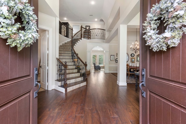 foyer with decorative columns, recessed lighting, stairway, dark wood finished floors, and a notable chandelier