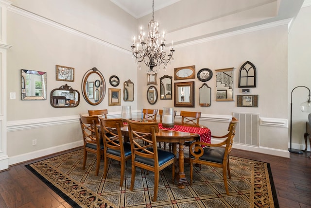 dining area featuring hardwood / wood-style flooring, ornamental molding, visible vents, an inviting chandelier, and baseboards