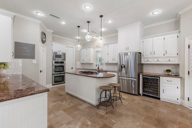 kitchen featuring wine cooler, ornamental molding, backsplash, stainless steel appliances, and white cabinets