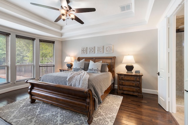 bedroom featuring hardwood / wood-style flooring, ornamental molding, visible vents, a raised ceiling, and baseboards