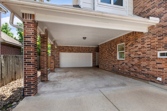 view of patio featuring concrete driveway and fence