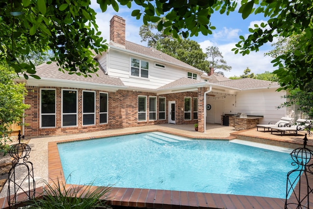 pool featuring exterior kitchen and a patio area