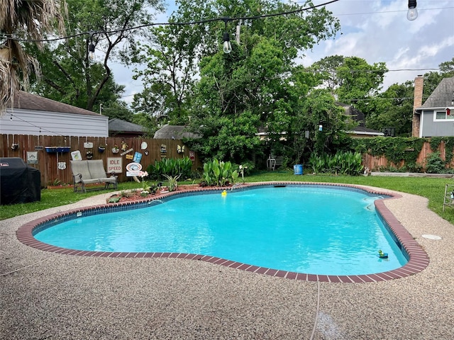 view of swimming pool with a grill, a fenced backyard, and a fenced in pool