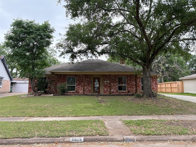 ranch-style home with a front yard, roof with shingles, brick siding, and fence