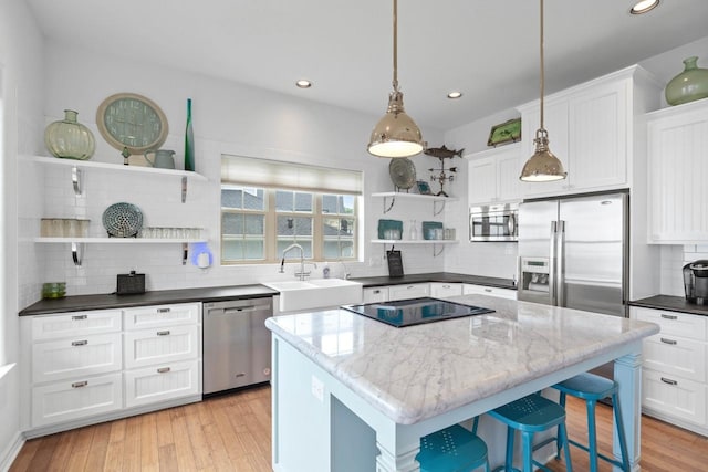 650 Dove Is, Livingston, TX 77351 - kitchen featuring a sink, open shelves, white cabinets, backsplash, and appliances with stainless steel finishes