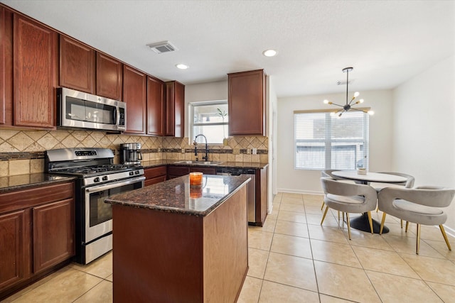 2614 Magnolia Fair Way, Spring, TX 77386 - kitchen with a sink, stainless steel appliances, visible vents, decorative backsplash, and a center island