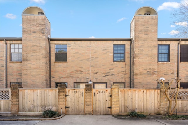 9850 Pagewood Ln Unit 1302, Houston, TX 77042 - back of house with a gate, fence, and a chimney