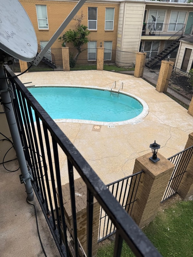 community pool with fence and a patio