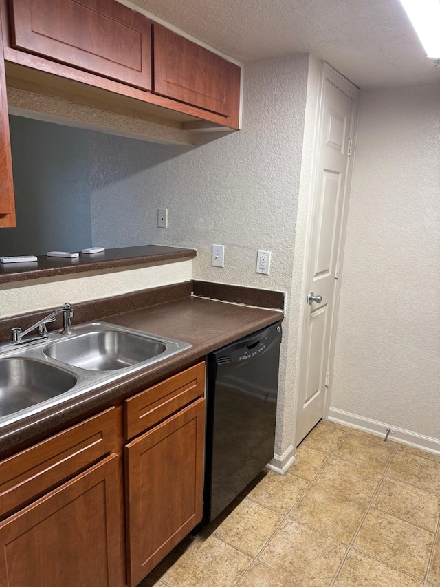 kitchen featuring a sink, black dishwasher, a textured wall, baseboards, and dark countertops