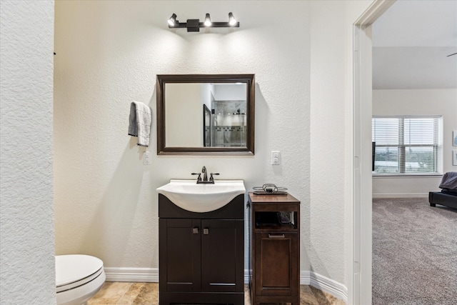 1210 Persimmon Pass, Fischer, TX 78623 - bathroom featuring vanity, toilet, a textured wall, and baseboards