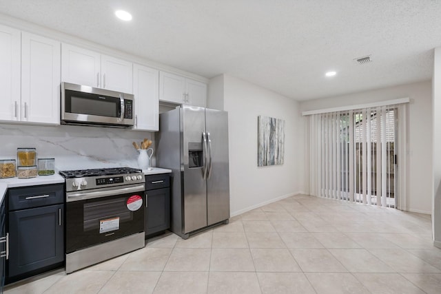 34 Quiet Peace Pl, The Woodlands, TX 77381 - kitchen with appliances with stainless steel finishes, white cabinetry, light countertops, recessed lighting, and backsplash