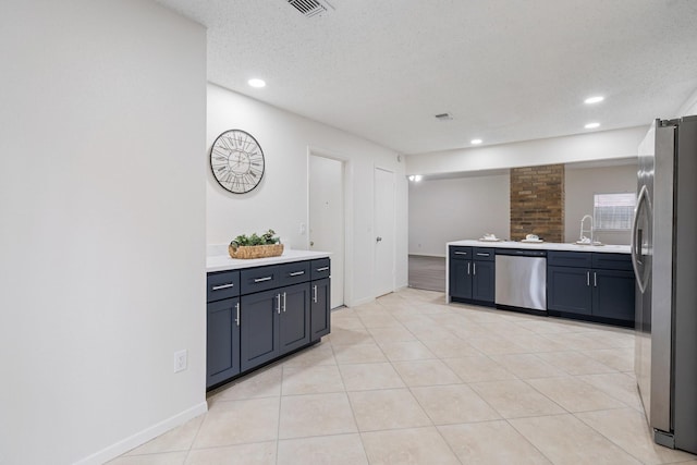 34 Quiet Peace Pl, The Woodlands, TX 77381 - kitchen with appliances with stainless steel finishes, light countertops, a textured ceiling, recessed lighting, and light tile patterned flooring