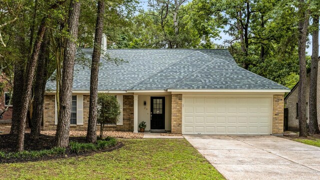 34 Quiet Peace Pl, The Woodlands, TX 77381 - single story home with a shingled roof, a garage, driveway, a front lawn, and brick siding